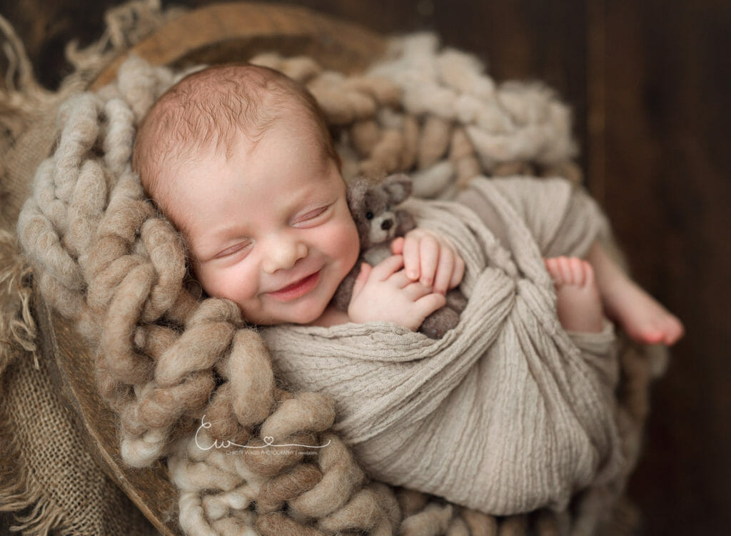Best San Diego Newborn Photographer San Diego newborn baby boy with natural organic fluff laying in a basket